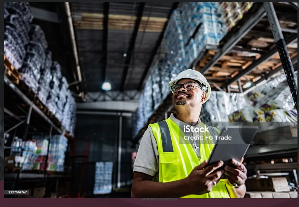 Operations supervisor reviewing shipment data on a tablet inside a Sharjah logistics facility